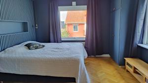 a bedroom with a bed and a large window at Spacious House near Sea - Delightful shelted garden in Varberg