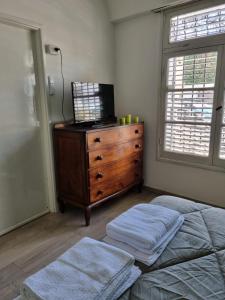 a bedroom with a dresser and a bed with two towels at Casa Amplia en Pleno Centro Histórico in Salta
