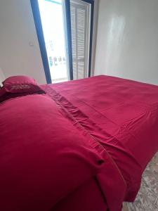 un gran edredón rojo en una cama en un dormitorio en Villa Triplex Palm Beach en Pont Blondin