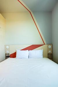 a bedroom with a large white bed with a red headboard at Hotel Ibis Budget Montpellier Centre Millenaire - in Montpellier