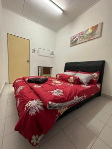 una camera da letto con un piumone rosso su un letto di Naurah Homestay Kulai Mslim Only a Kulai