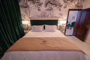 ein Schlafzimmer mit einem großen Bett und einer grünen Wand in der Unterkunft HT Hotel Deluxe Resort & SPA in Santiago del Estero