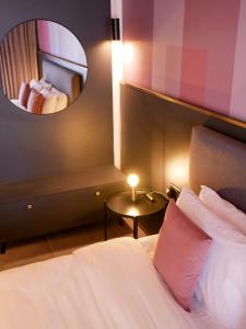 a hotel room with a bed and a mirror at Eleven by Warren Collection in Sliema
