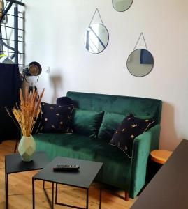 uma sala de estar com um sofá verde e uma mesa em Maison d'hôtes entre Gap et Sisteron em Lazer
