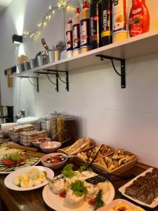 a buffet with plates of food on a table at Greg&Tom Beer House Hostel in Kraków