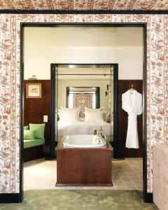 a bathroom with a bed and a bath tub in a room at Les Suites Cinabre in Paris