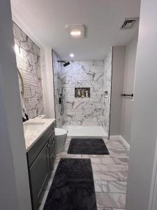 a white bathroom with a stone wall at Single family Home ONLY long term booking of 28 days or longer in Boston