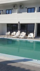 西洛卡特倫的住宿－Evita Blue，一组椅子和一个游泳池