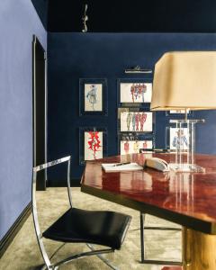 a desk with a lamp and a chair in a room at Les Suites Cinabre in Paris