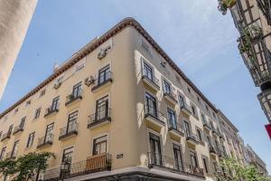 een groot geel gebouw met balkons in een straat bij Modern apartment in Chueca INF3Iz4 in Madrid