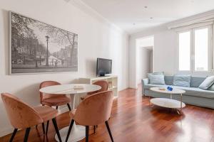 een woonkamer met een bank, een tafel en stoelen bij Modern apartment in Chueca INF3Iz4 in Madrid