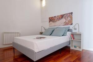 een slaapkamer met een groot wit bed met blauwe kussens bij Modern apartment in Chueca INF3Iz4 in Madrid