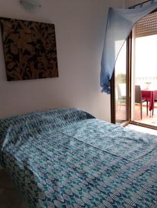 Schlafzimmer mit einem Bett mit blauer Decke in der Unterkunft Appartamento da Monica in Tortolì