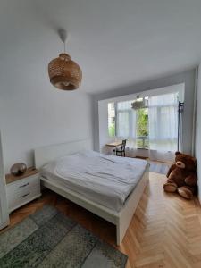 a bedroom with a bed and a teddy bear on the floor at Spacious and quiet 1BR apartment in Floreasca in Bucharest