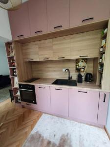 a kitchen with white cabinets and a sink at Spacious and quiet 1BR apartment in Floreasca in Bucharest