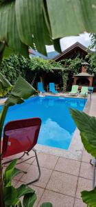 a swimming pool with a red chair and chairs at APARTMAN MURKO S-1 