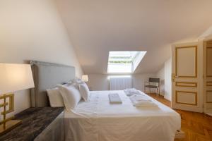 una camera da letto con un grande letto bianco con una finestra di CASA CON PISCINA EN EL CENTRO a Tudela Altre 25 foto