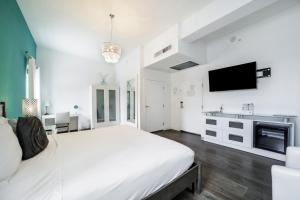 فندق إيثاكا أوف ساوث بيتش في ميامي بيتش: غرفة نوم بيضاء مع سرير كبير وتلفزيون