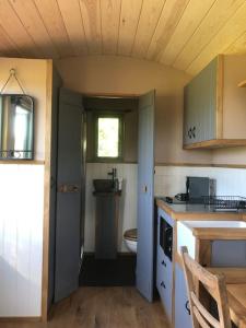 a small kitchen with a sink and a window at The Shepherd’s Hut in Whiteparish