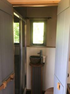 a bathroom with a bowl sink and a window at The Shepherd’s Hut in Whiteparish