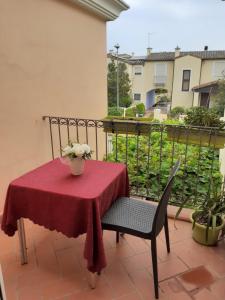 a table and chair with a red table cloth on a balcony at Appartamento da Monica in Tortolì