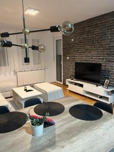 a living room with a couch and a tv at Loft Luxury Apartment in Pirot