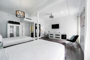 فندق إيثاكا أوف ساوث بيتش في ميامي بيتش: غرفة نوم بيضاء بسريرين وكرسي