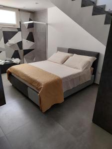1 dormitorio con 1 cama grande y escalera en Villa Aria di sole en Francavilla Fontana