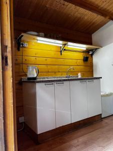 uma cozinha com um lavatório e uma parede amarela em Glamping de Cerveira em Vila Nova de Cerveira