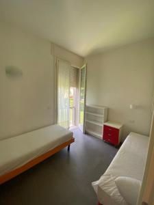 a white room with two beds and a window at Appartamento Pirandello in Lido di Camaiore