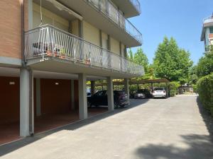 a balcony on the side of a building with parked cars at Appartamento Pirandello in Lido di Camaiore