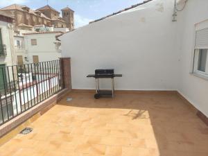 un balcón con una mesa en la parte superior de una pared blanca en apartamentos El-Hizan, en Laujar de Andarax