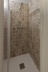 y baño con ducha y pared de azulejos. en apartamentos El-Hizan, en Laujar de Andarax