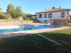 Villa La Escollera Ronda في أرياتي: بيت فيه مسبح قدام بيت
