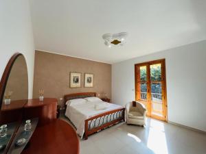 a bedroom with a bed and a desk and a window at Casa Manila in Avola