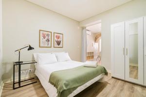 una camera bianca con un letto e una finestra di Metropolitan Living Lisbon - Janelas Verdes a Lisbona