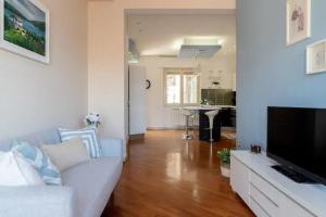 sala de estar con sofá blanco y TV en Etna City Home Accogliente nel cuore di Catania, en Catania
