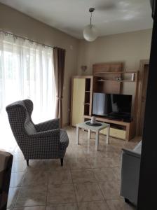 a living room with a chair and a television at Apartman Lucia in Bilice