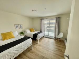 una camera da letto con due letti e una finestra di APPART-HOTEL L'UNI a Québec