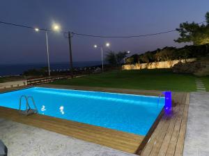 a blue swimming pool with a view of the ocean at Kallithea Residence in Koskinou