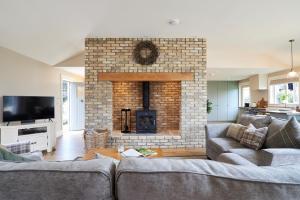 a living room with a brick fireplace with two couches at Lovely home close to Killaloe and Lough Derg in Raheen Bridge