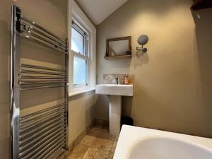 a bathroom with a tub and a sink and a window at Chic Listed House with Harbour and River Views in Central Cowes - Walk to top restaurants in East Cowes +82 photos