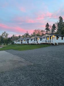 a row of white houses on a gravel road at Les chalets de la colline inc in Baie-Sainte-Catherine