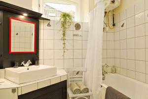 y baño con lavabo blanco, bañera y ducha. en Kurucz Apartman en Sárospatak