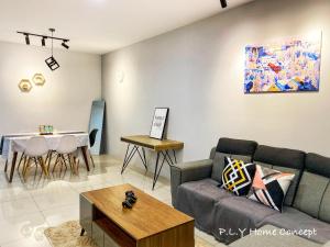 un soggiorno con un divano e un tavolo di Groundfloor Poolside Manhattan Ipoh Free Netflix&Carpark a Ipoh