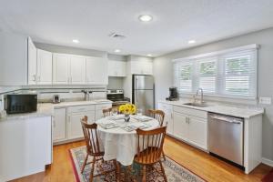 a kitchen with white cabinets and a table with chairs at Connecticut Retreat Steps to Historic Downtown! in Litchfield