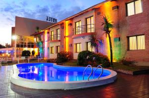 a swimming pool in front of a building at Costanera Hotel in Villa Carlos Paz