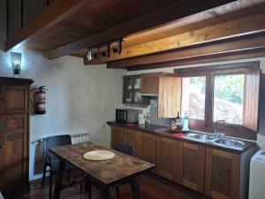 a kitchen with a table and a sink and a window at CASA RURAL CON PISCINA PRIVADA El ROBLE in Moya