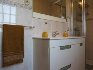 een badkamer met een wastafel, een spiegel en een handdoek bij Casa da Fonte in Monção