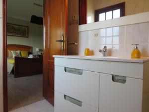 eine Küche mit einem Waschbecken und ein Schlafzimmer in der Unterkunft Casa da Fonte in Monção